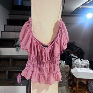 Off the shoulder pink top with measured ruffles.